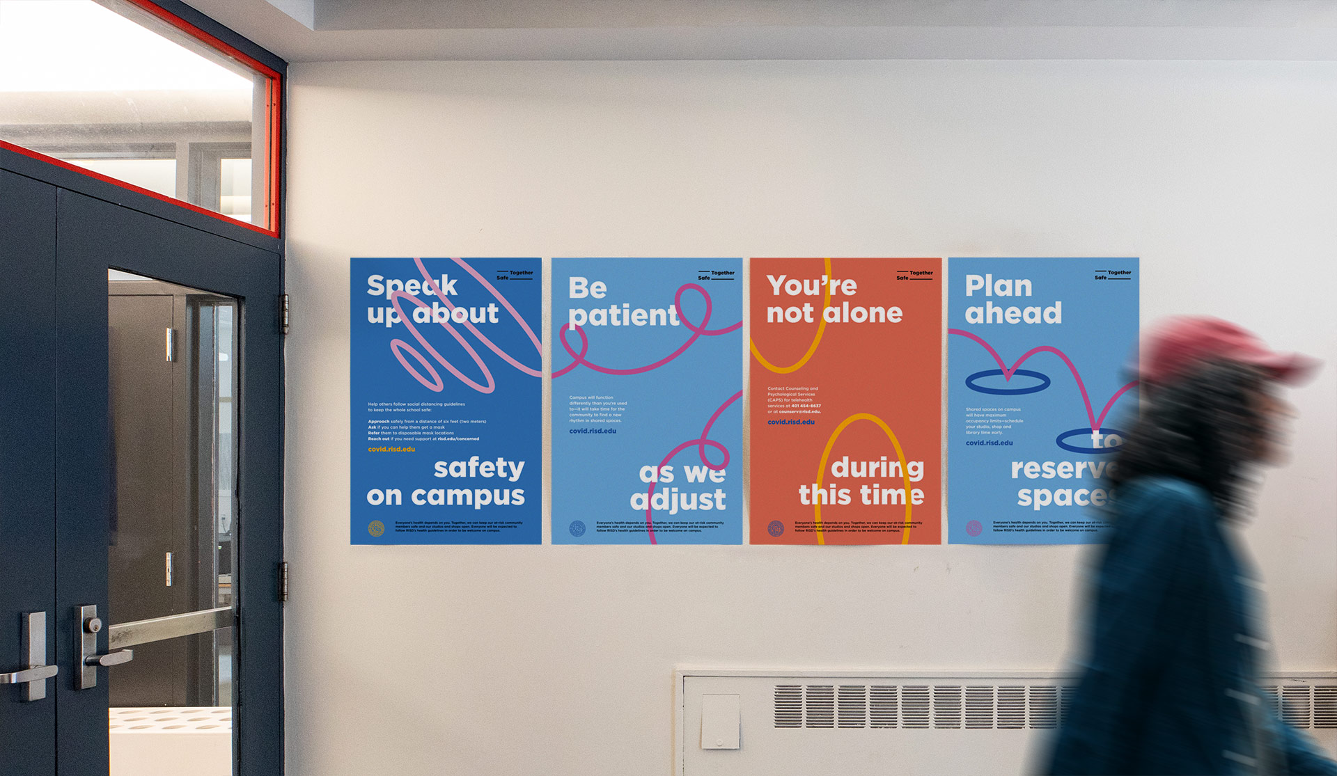 A hallway with four RISD Safe Together campaign posters